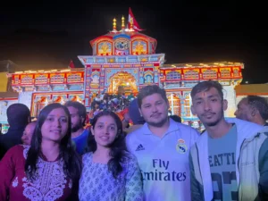 Travellers outside illuminated Badrinath Temple at night